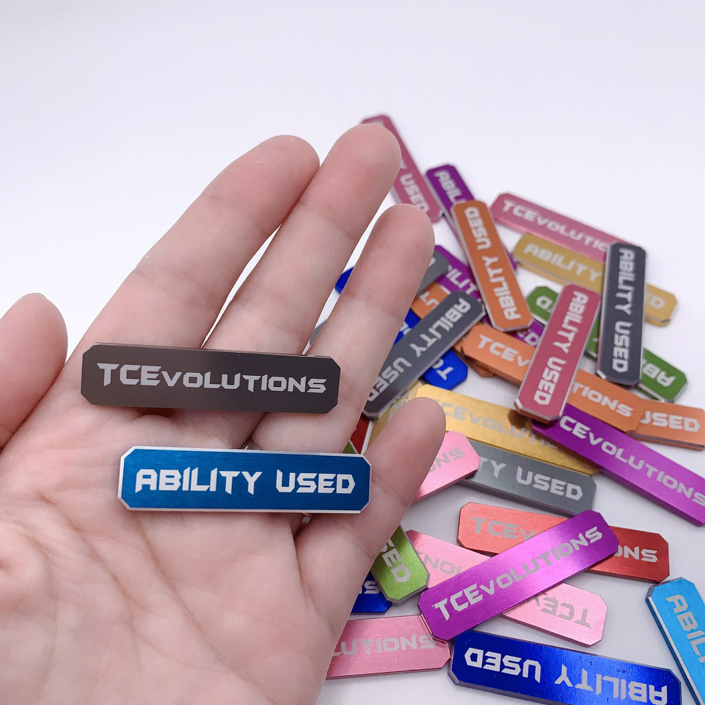 Pokémon TCG aluminum ability marker dice shown in hand for scale – premium metal damage counters TCEvolutions US